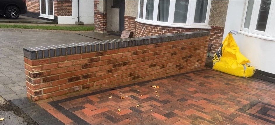Boundary wall, dark copings and paving edge